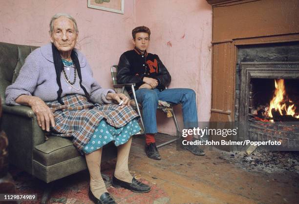 An elderly woman with his grandson near a fireplace at home, Pike County, Kentucky, US, 1967.