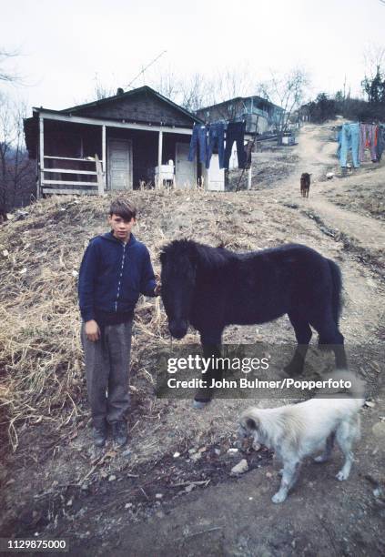 Boy with a pony and a dog in a village, Pike County, Kentucky, US, 1967.