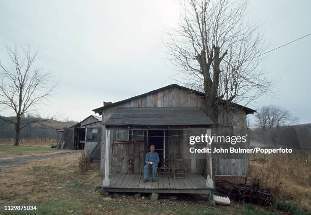 An elderly man sitting on the porch of his log house, Pike County, Kentucky, US, 1967.