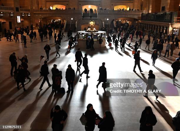 Commuters walk through the morning bright sunlight coming from the 60 feet high windows in Grand Central Terminal in New York City on March 11, 2019...