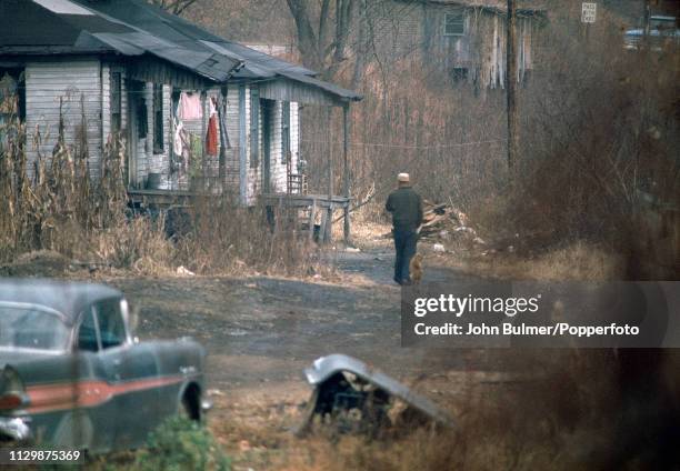 Man walking on a dirt road followed by a dog, Pike County, Kentucky, US, 1967.