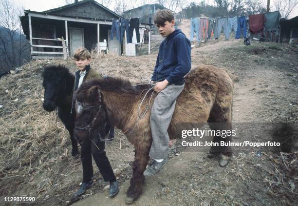 Two boys with ponies on a dirt road, Pike County, Kentucky, US, 1967.