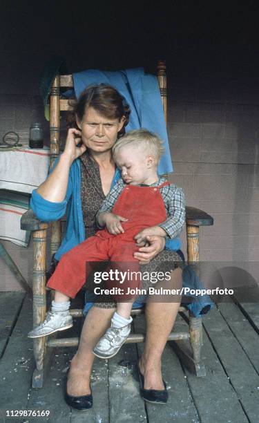 Woman with her child sitting on a wooden chair, Pike County, Kentucky, US, 1967.