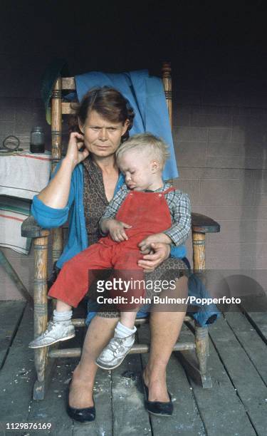 Woman with her child sitting on a wooden chair, Pike County, Kentucky, US, 1967.