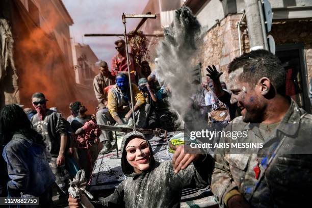 Masked reveller gestures as he takes part in a colourful 'flour war' during 'Ash Monday' celebrations, a traditional festivity marking the end of the...