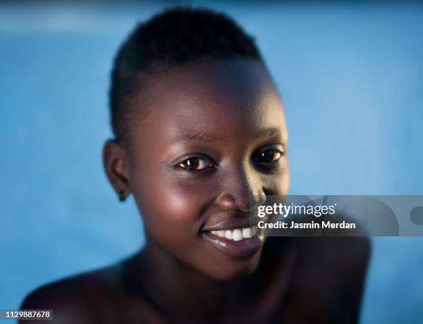 beautiful black girl on blue background - girl short hair stock pictures, royalty-free photos & images