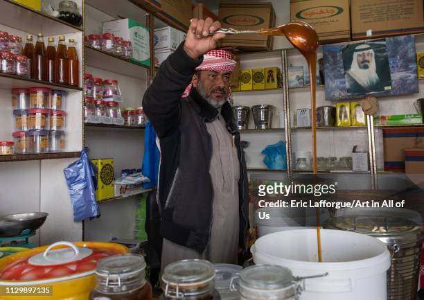 Saudi man selling honey in a shop, Asir province, Abha, Saudi Arabia on December 9, 2018 in Abha, Saudi Arabia.