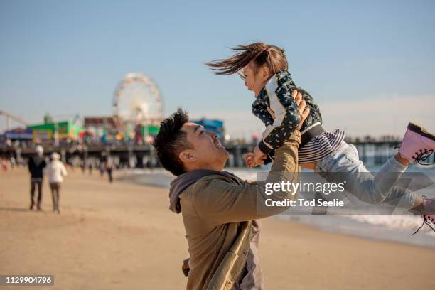 multi-ethnic family on winter beach picnic santa monica - santa monica pier foto e immagini stock