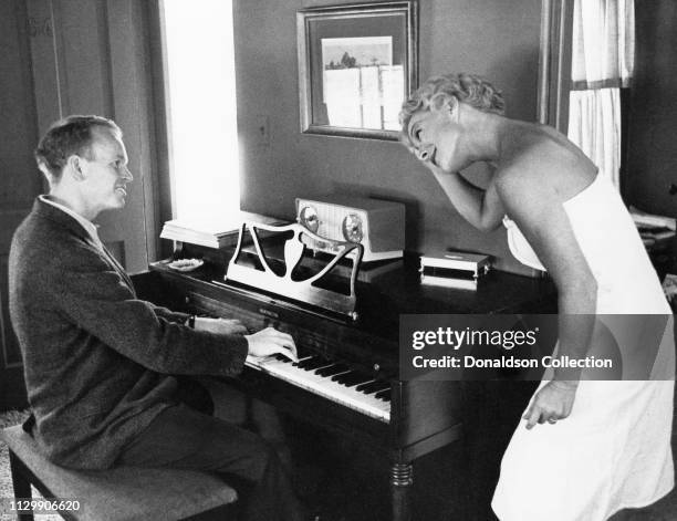 Actress Betty Hutton poses for a portrait with a man playing piano in circa 1958.