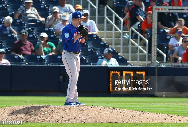 Eric Hanhold of the New York Mets gets set to deliver a pitch as the pitch clock counts down during the ninth inning of a spring training baseball...