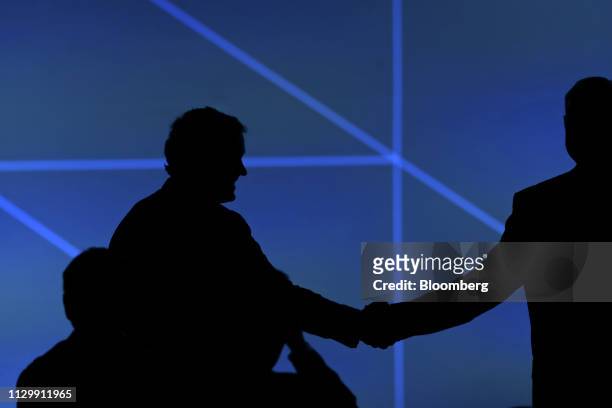 Attendees are seen silhouetted shaking hands during the 2019 CERAWeek by IHS Markit conference in Houston, Texas, U.S., on Monday, March 11, 2019....
