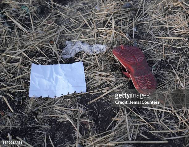 Personal effects lay in the open in the debris field just outside of the impact crater during the continuing recovery efforts at the crash site of...