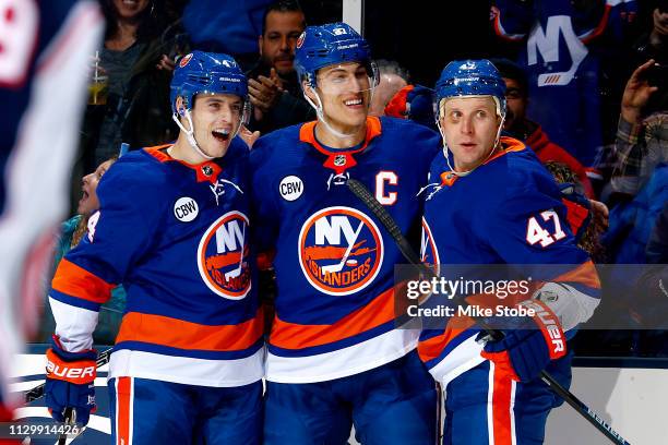 Anders Lee of the New York Islanders is congratulated by his teammates Leo Komarov and Thomas Hickey after scoring a third-period empty-net goal...