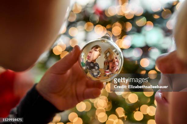 reflection of two boys making funny faces in a christmas bauble - 異常角度 個照片及圖片檔