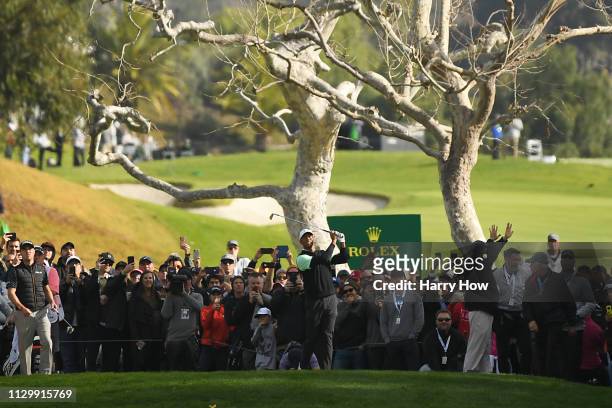 Tiger Woods hits a tee shot on the 4th hole during the continuation of the first round of the Genesis Open at Riviera Country Club on February 15,...