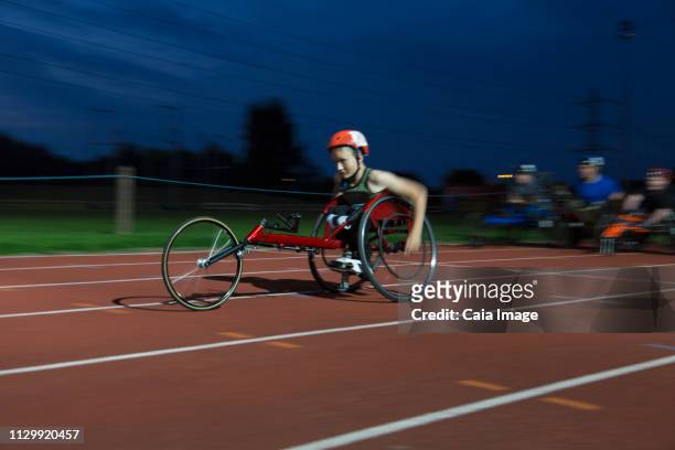teenage paraplegic athlete speeding along sports track in wheelchair race - paraplegic race stock pictures, royalty-free photos & images