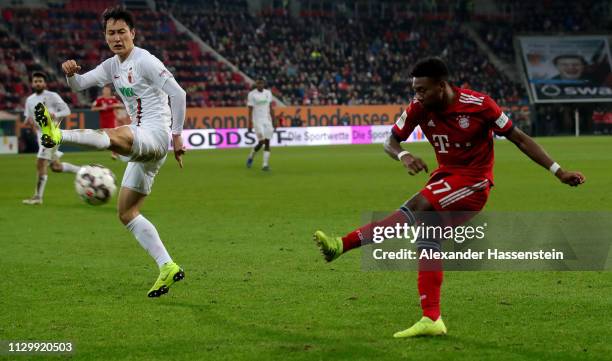 David Alaba of Muenchen shoots at goal during the Bundesliga match between FC Augsburg and FC Bayern Muenchen at WWK-Arena on February 15, 2019 in...