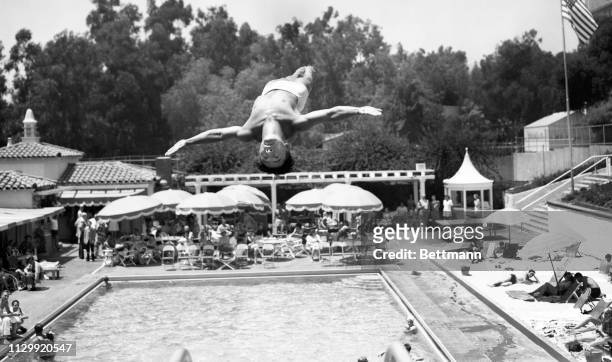 National diving champ Sammy Lee is stopped by the camera in midair, as he does an intricate back flip during the Aquatic Fete at the Sand and Pool...