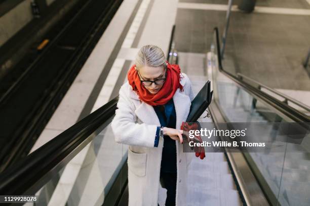 businesswoman late for work - mirar la hora fotografías e imágenes de stock