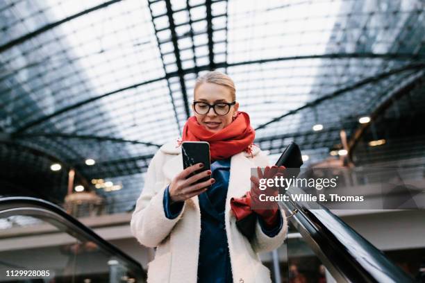 businesswoman texting on way to the office - red glove stock-fotos und bilder