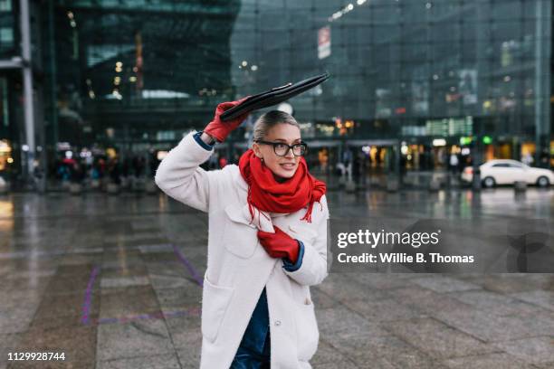 businesswoman running on rainy day - red scarf stock-fotos und bilder