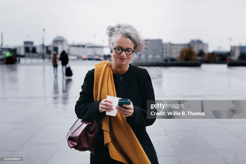 Businesswoman Smiling While Texting On Her Lunch Break