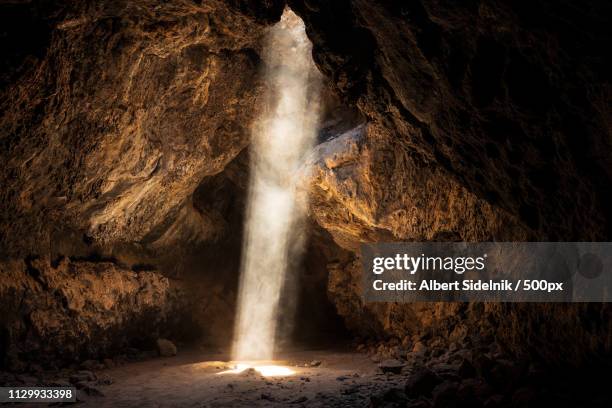 cave with light coming through hole - caverne stock pictures, royalty-free photos & images