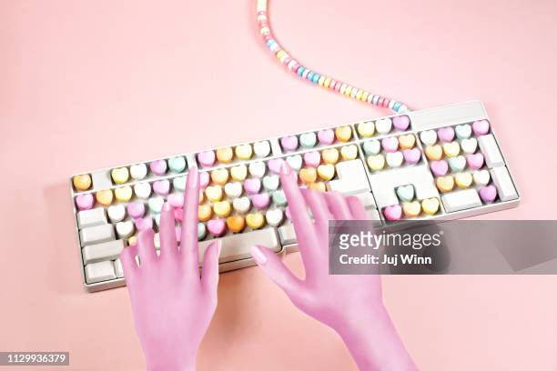 digital illustration of hands typing on a candy keyboard - love letter stock-fotos und bilder