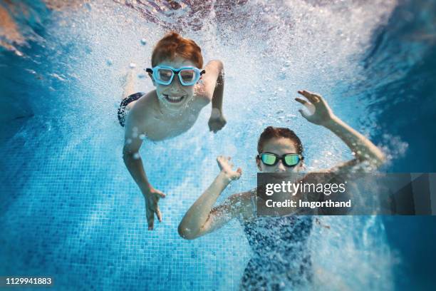 broer en zus spelen in zwembad. - under water stockfoto's en -beelden