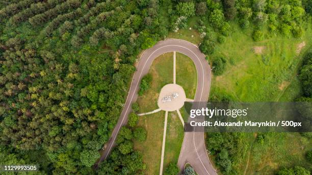 abrupt turn road through the green forest view from above - abrupt forest stock pictures, royalty-free photos & images