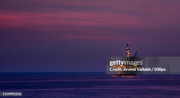 drilling rig at purple dusk - drilling rig stock-fotos und bilder