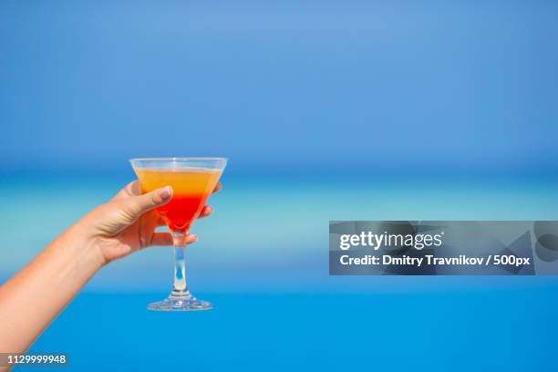 woman holding cocktail on tropical beach - margarita beach stock-fotos und bilder