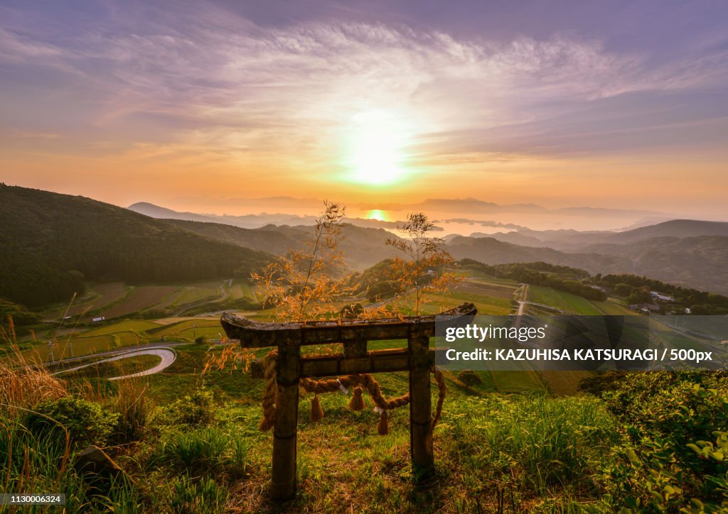 Torii gate in mountains at sunset