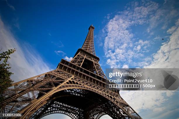 low angle view of eiffel tower under blue sky - 視点 stock pictures, royalty-free photos & images