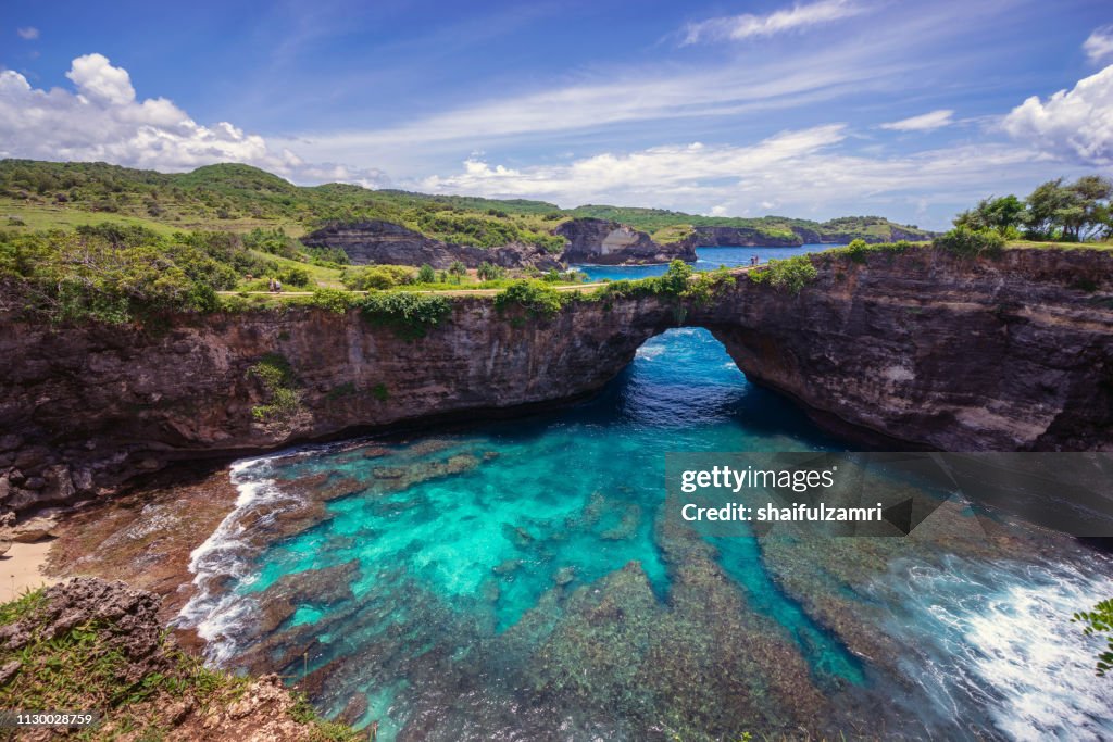 Beautiful arched broken beach with big waves and crystal clear water in Nusa Penida in Bali, Indonesia.