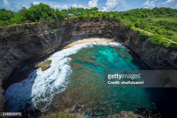 beautiful arched broken beach with big waves and crystal clear water in nusa penida in bali, indonesia. - bay of water fotografías e imágenes de stock