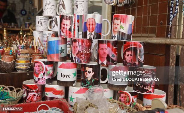 Mugs bearing the portraits of Syrian President Bashar al-Assad and Russian President Vladimir Putin are sold in the old Syrian city of Damascus on...