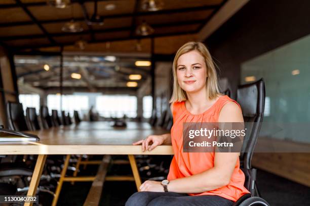 confident businesswoman on wheelchair in board room - wheelchair office stock pictures, royalty-free photos & images