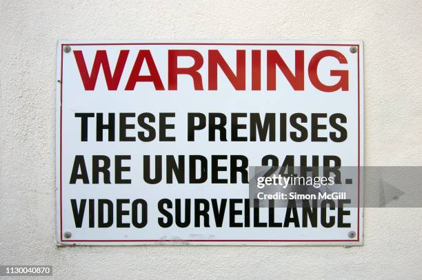 'warning: these premises are under 24 hour video surveillance' sign on a building exterior wall - private property stock pictures, royalty-free photos & images