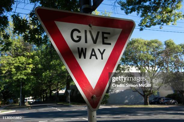 give way traffic sign at a road intersection - vorfahrt beachten stock-fotos und bilder