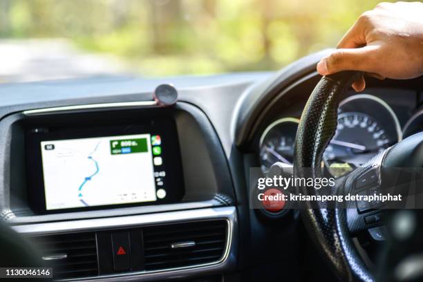 a man hand on steering wheel,using  satnav for driving directions at  chiang mai,thailand. date: 1/22/19, 12:52:44 - car display background stock pictures, royalty-free photos & images