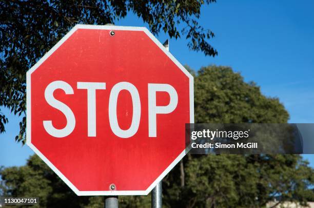 stop sign at a road intersection - stop sign stock pictures, royalty-free photos & images