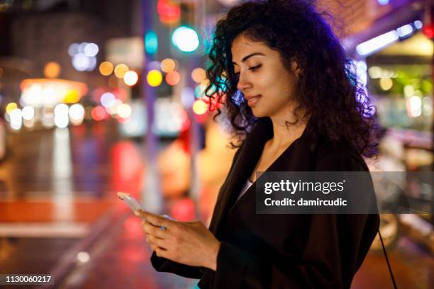 junge frau auf den straßen der großstadt bei nacht - arab woman walking stock-fotos und bilder