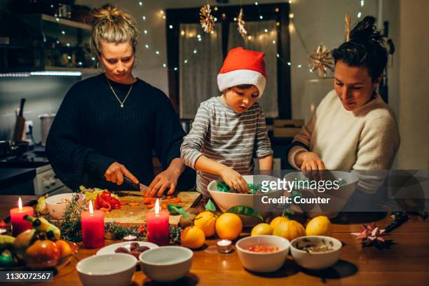 two women preparing christmas dinner with young boy - portugal food stock pictures, royalty-free photos & images