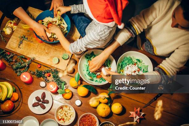 two women preparing christmas dinner with young boy - portugal food stock pictures, royalty-free photos & images