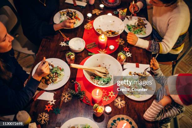 family eating christmas dinner - weihnachtsessen stock-fotos und bilder