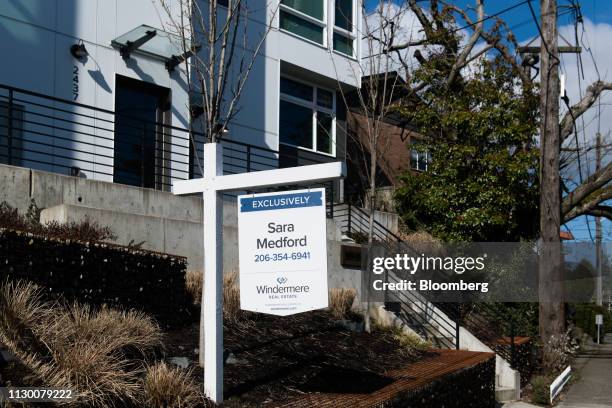 Real estate broker sign stands outside a townhouse in the Queen Anne neighborhood of Seattle, Washington, U.S., on Sunday, March 10, 2019. For the...