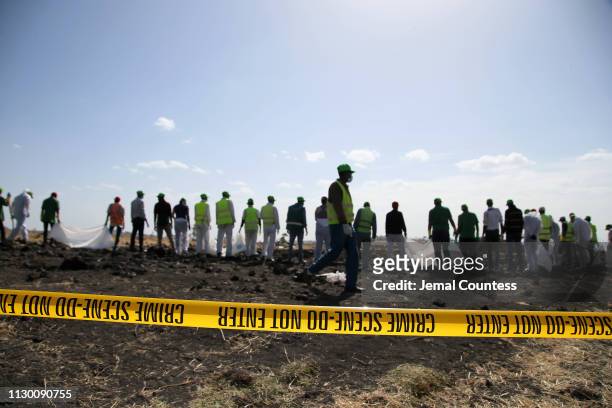 Forensics investigators and recovery teams collect personal effects and other materials from the crash site of Ethiopian Airlines Flight ET 302 on...