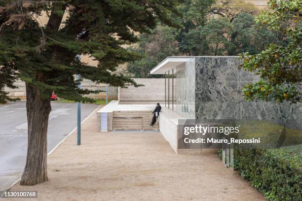 a man standing at the front of "the barcelona pavilion", at montjuic district in barcelona, spain. - mies van der rohe stock pictures, royalty-free photos & images