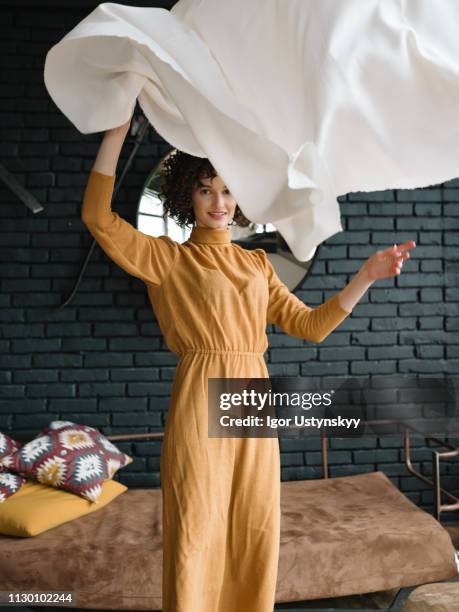 young woman holding laundry - sheet bedding stock pictures, royalty-free photos & images